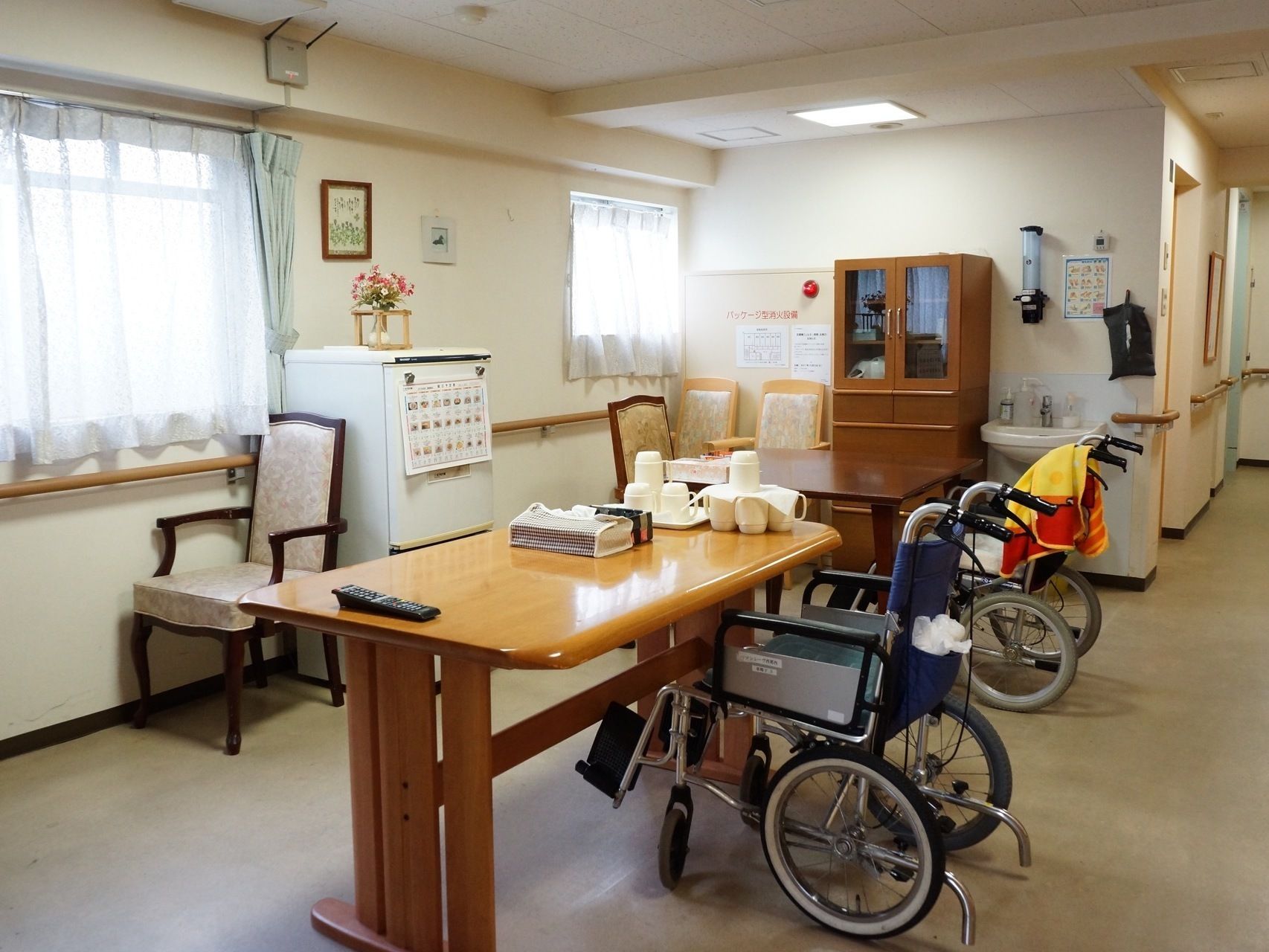 一つのテーブルに集まり塗り絵を楽しむ入居者と、それを見守るスタッフ