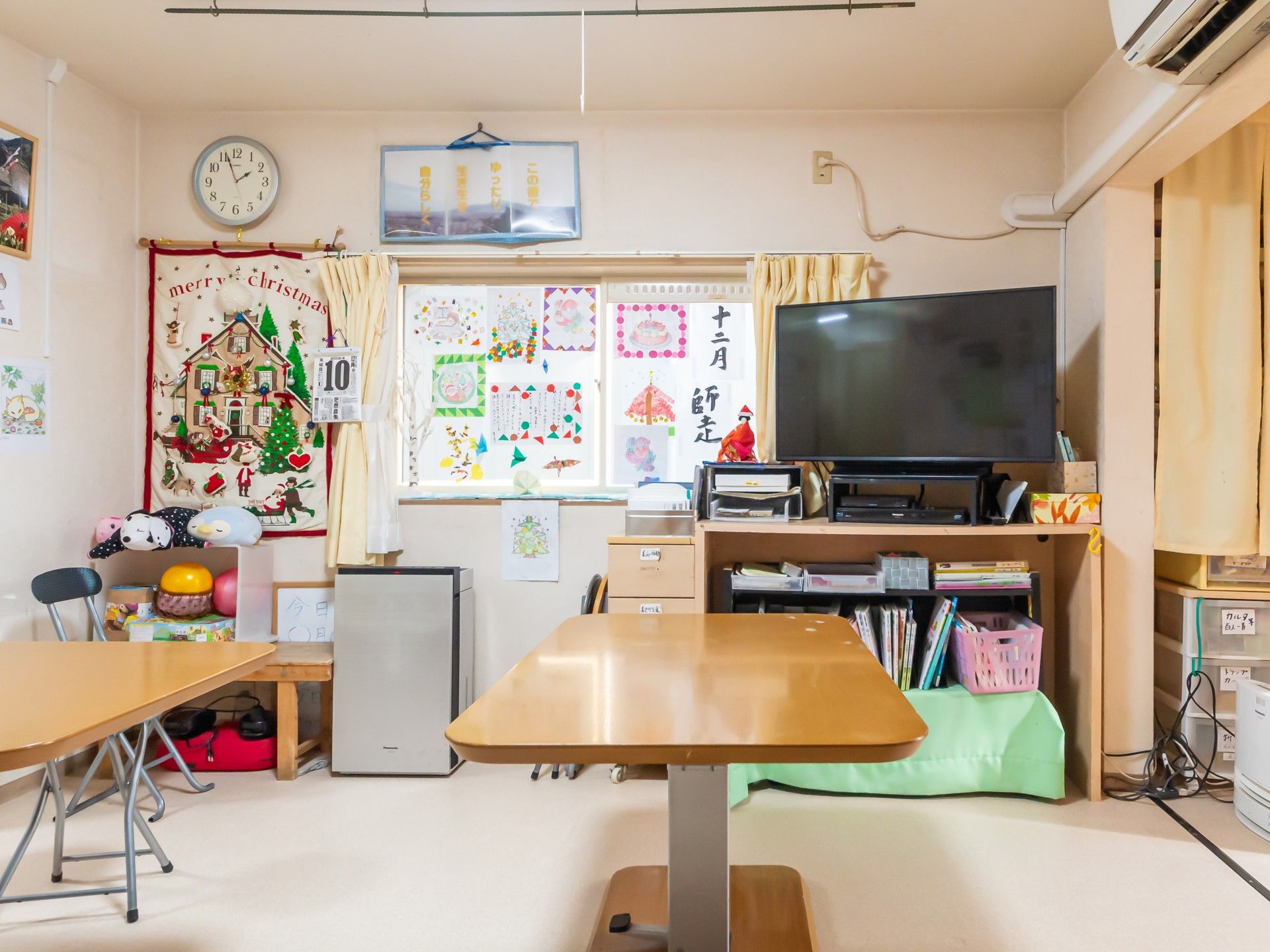 壁に飾られた作品とテレビ