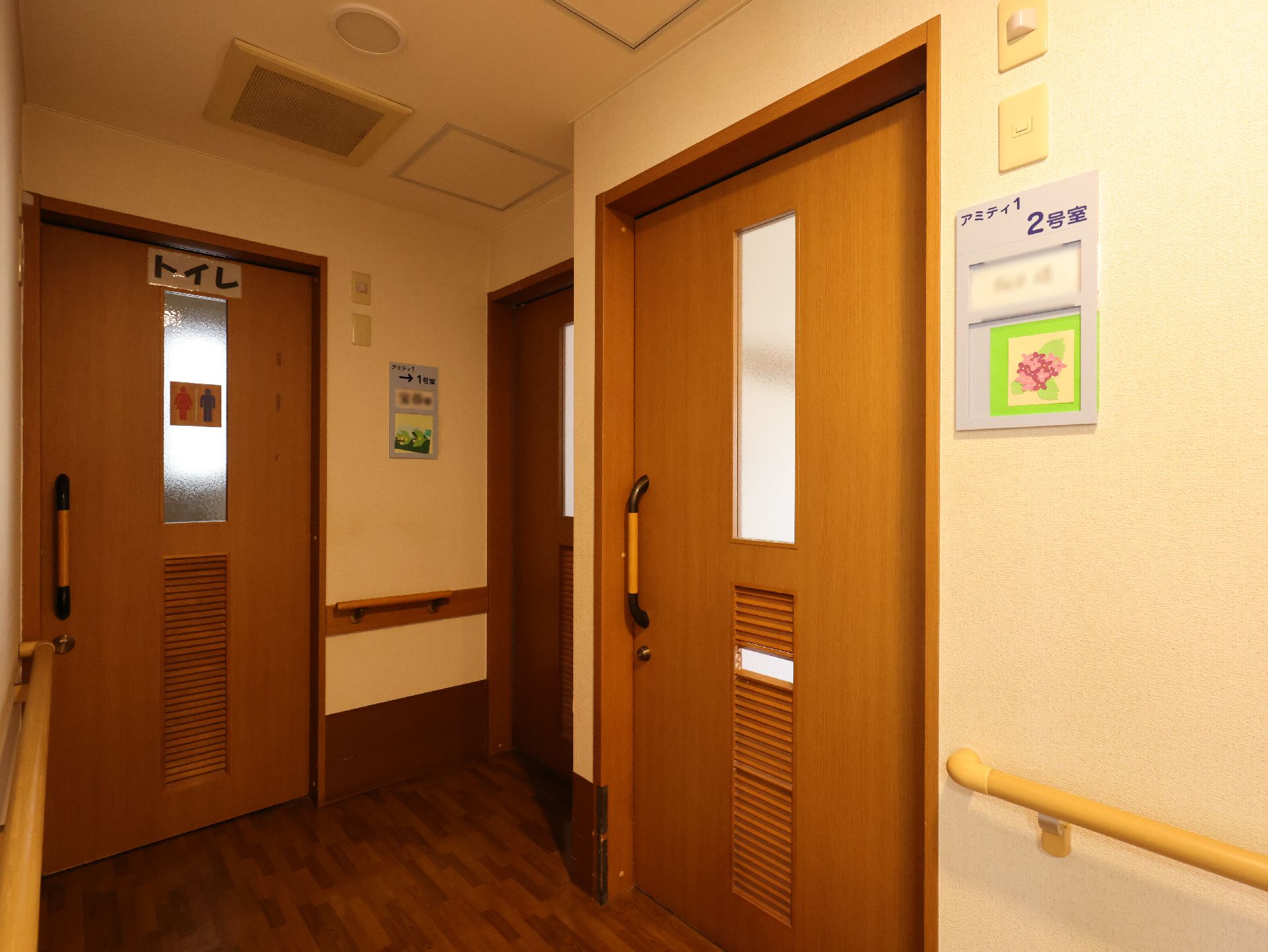 手すりと椅子が設置された、車椅子の入居者に配慮された廊下