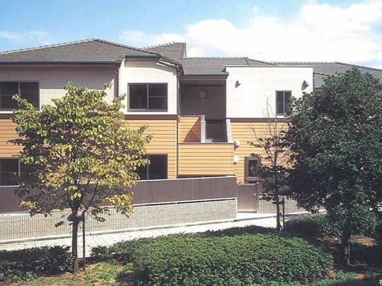 1階が茶色、2階と3階が白い外壁で三角屋根の2階建て建築物