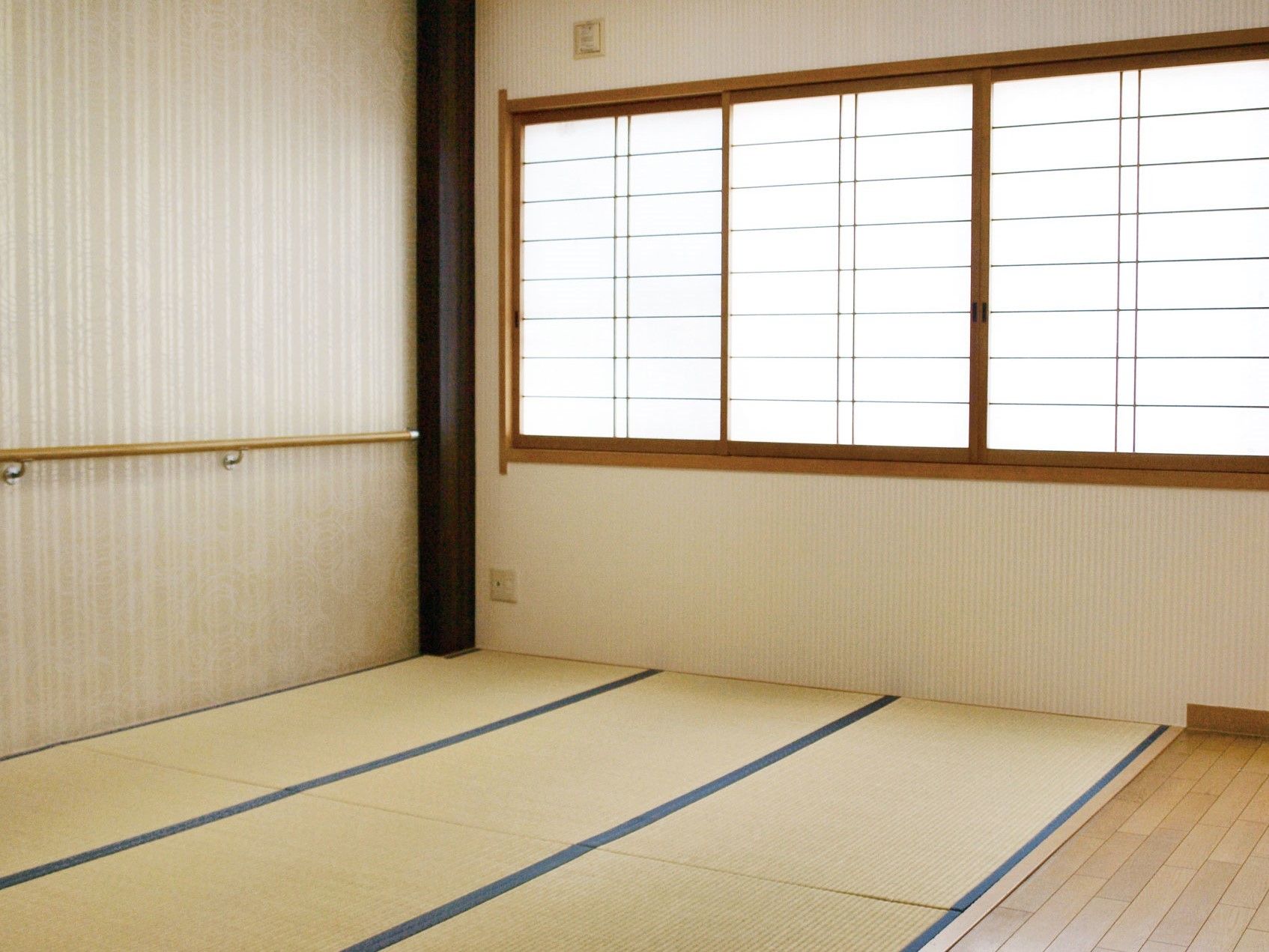 窓に障子がはめ込まれており、手すりが設置されている和室
