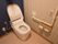 落ち着いた色合いのトイレである。洋式便座を完備。壁にはナースコール、L字型の手すりなどが設置されている。