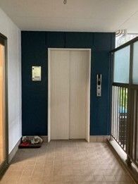白色にデザインされた、スタイリッシュなエレベーターが備えつけられている。まわりの壁色はピンクで、あたたかい雰囲気である。
