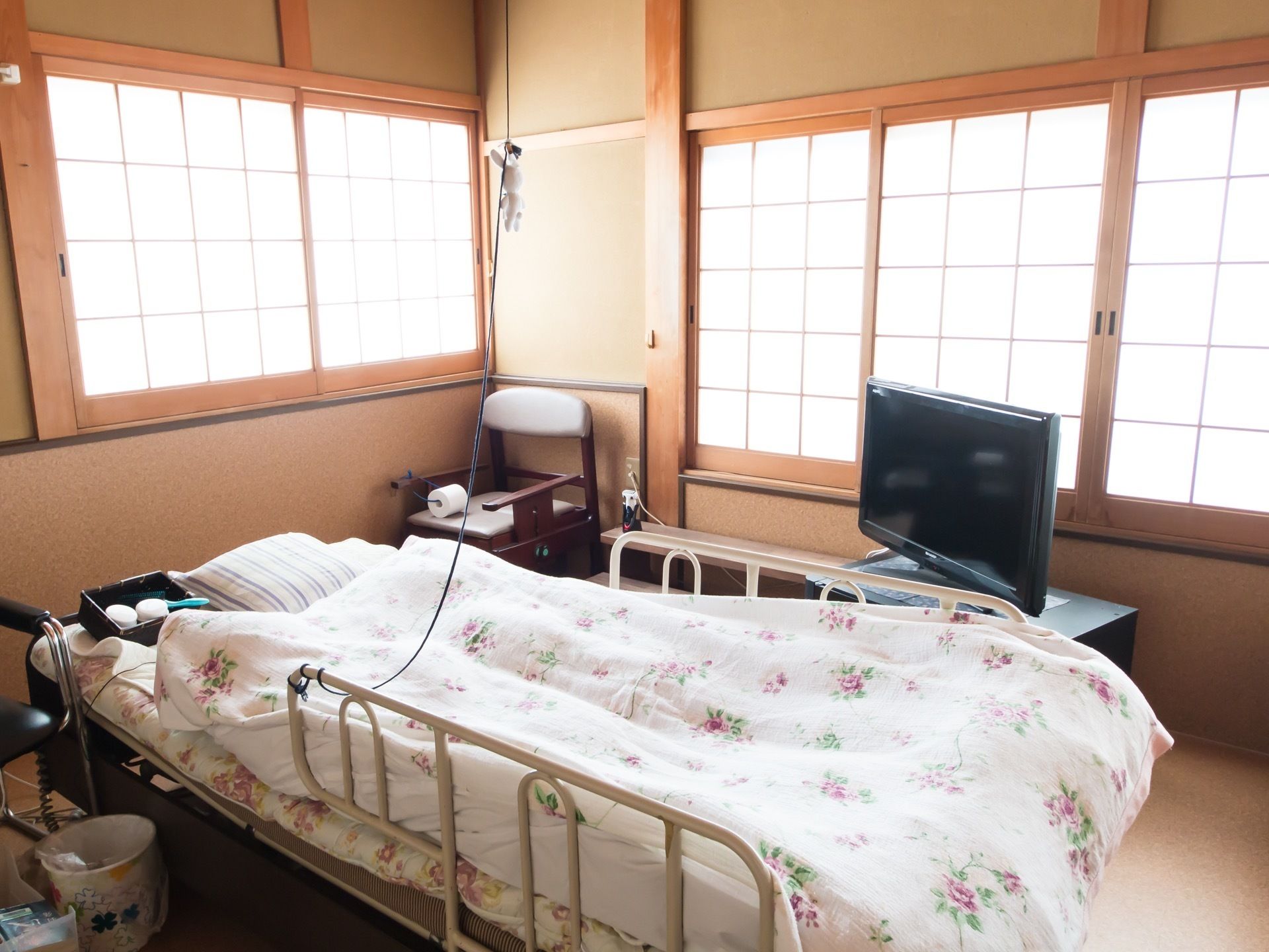 ２ヵ所の窓に、障子のドアがついている。中央に可動式のベッドを置き、電気がつけやすいよう紐を張っている。