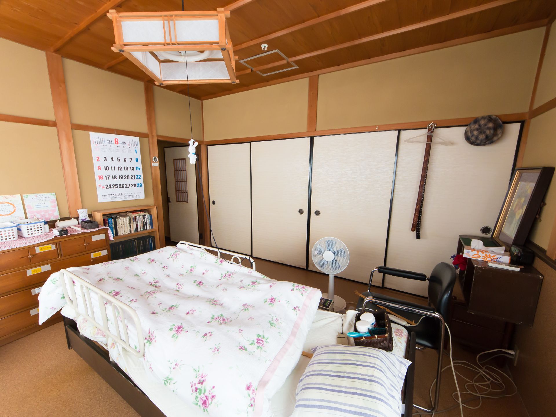 収納家具と中央に介護用ベッドが置かれている、襖で仕切られた部屋