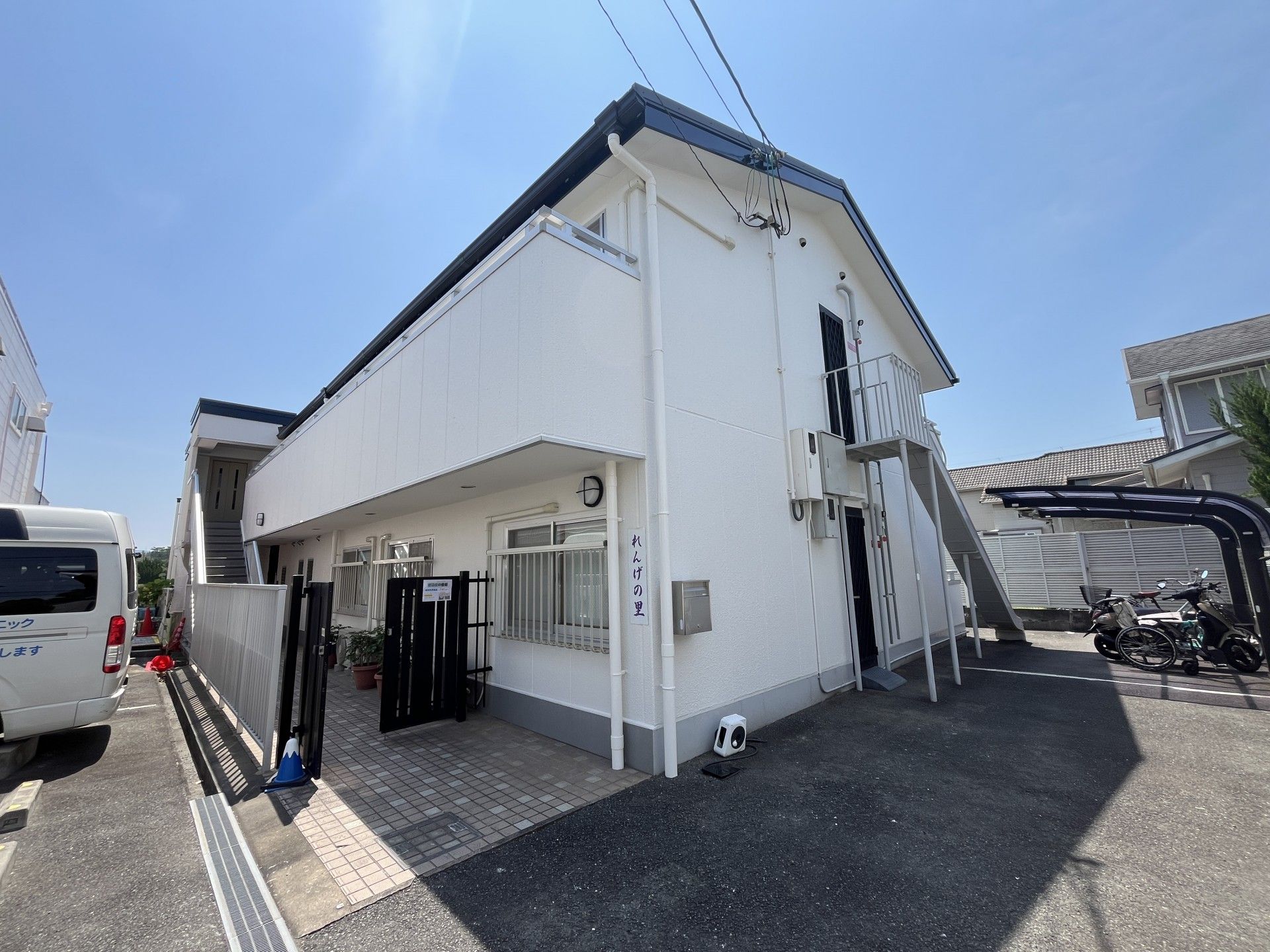 車椅子に乗った高齢女性と付き添いの女性ヘルパー