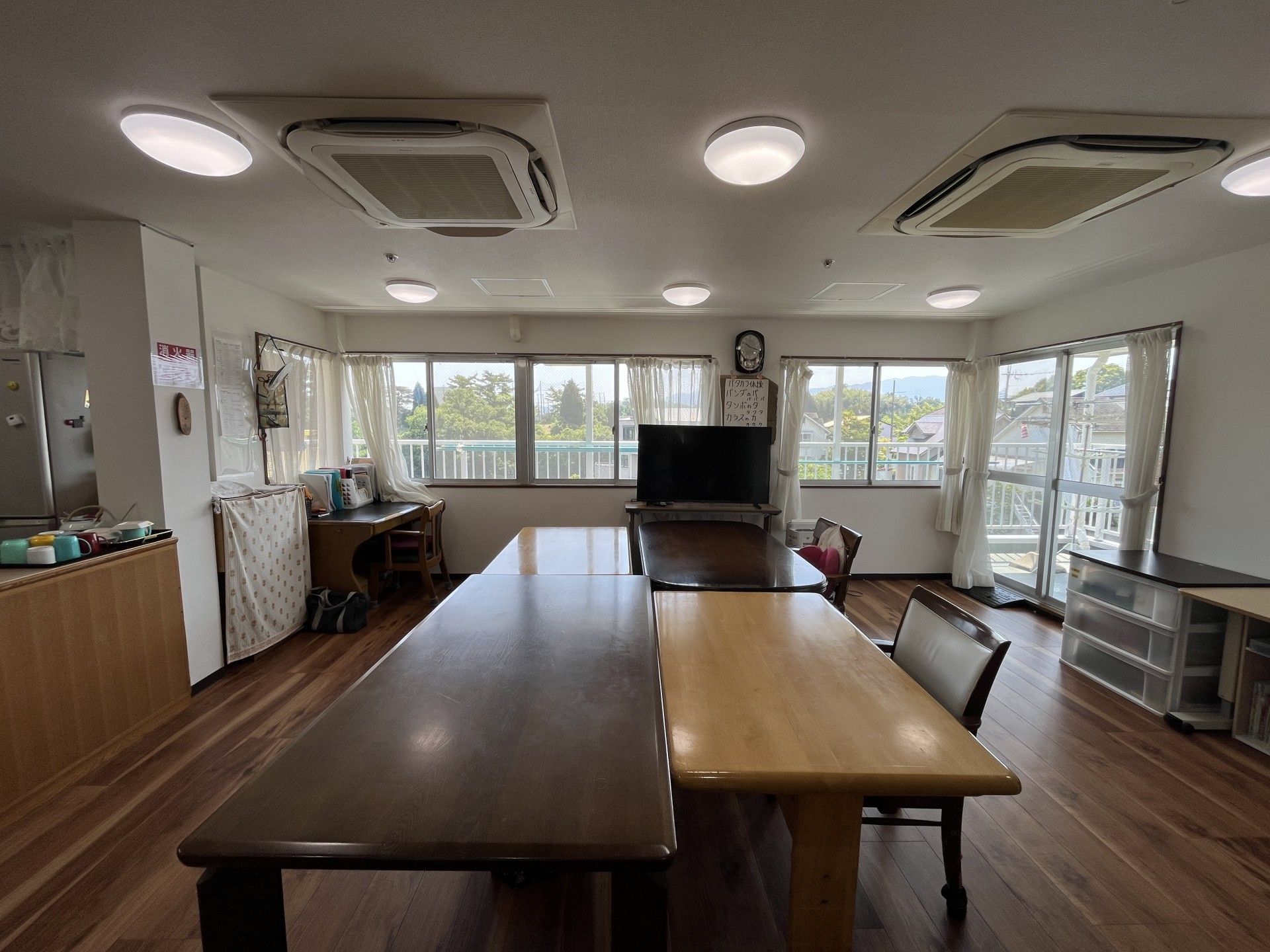 顔を見合わせる車椅子に乗った高齢女性と付き添いの女性ヘルパー