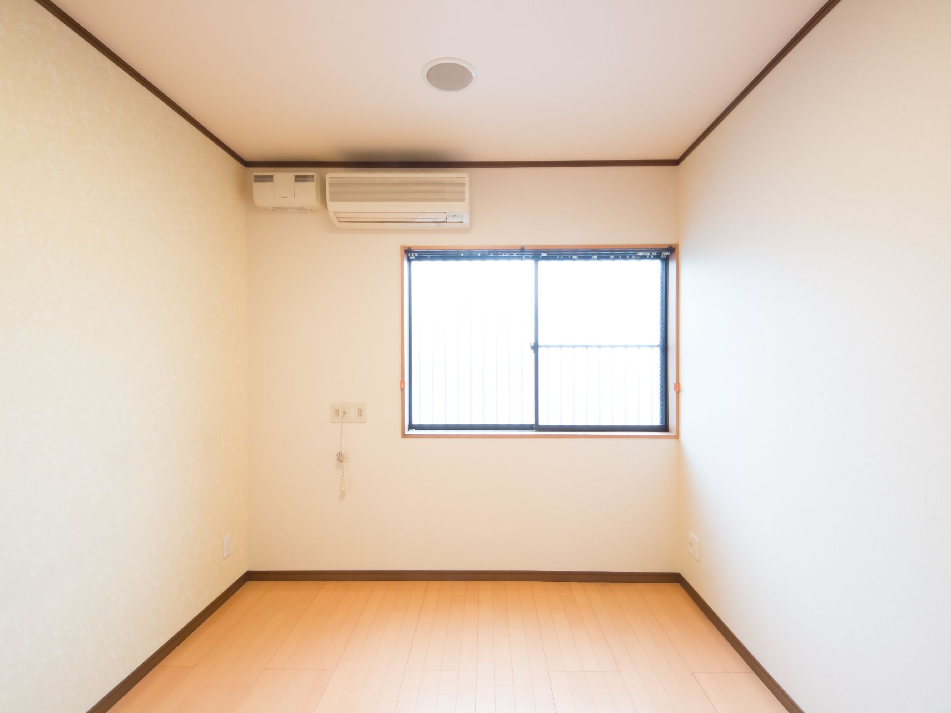 長方形の間取りの部屋で、窓が１か所開いている。窓の上にエアコンがあり、エアコンの下にナースコールのコードが出ている。