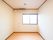 長方形の間取りの部屋で、窓が１か所開いている。窓の上にエアコンがあり、エアコンの下にナースコールのコードが出ている。
