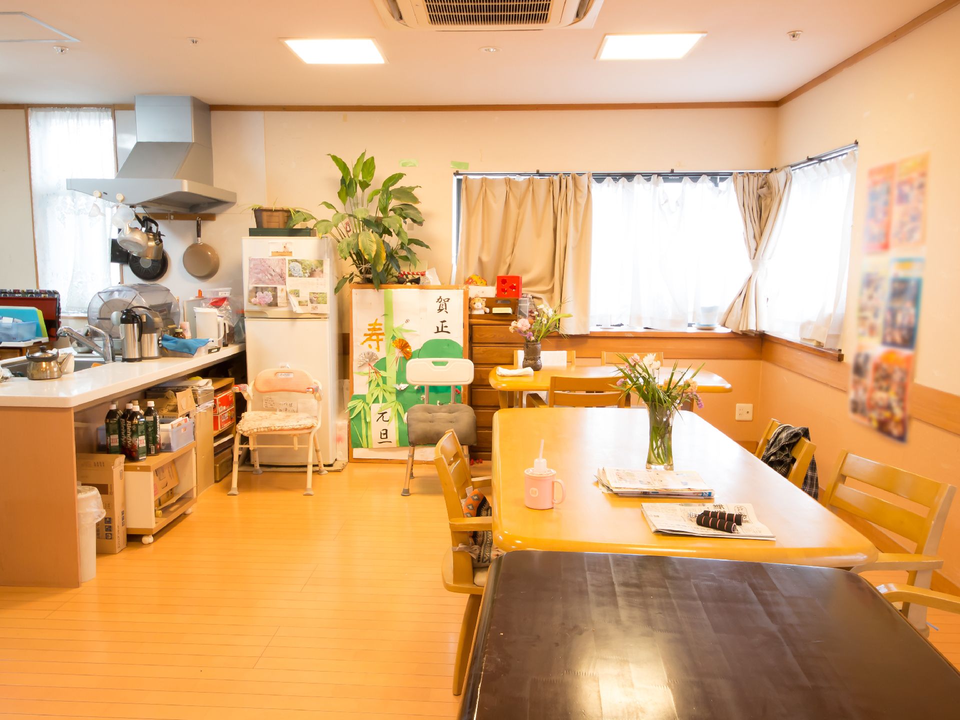 木材を基調としたダイニングである。テーブルの上には花瓶が飾られ、壁際にも大きな観葉植物が置かれている。