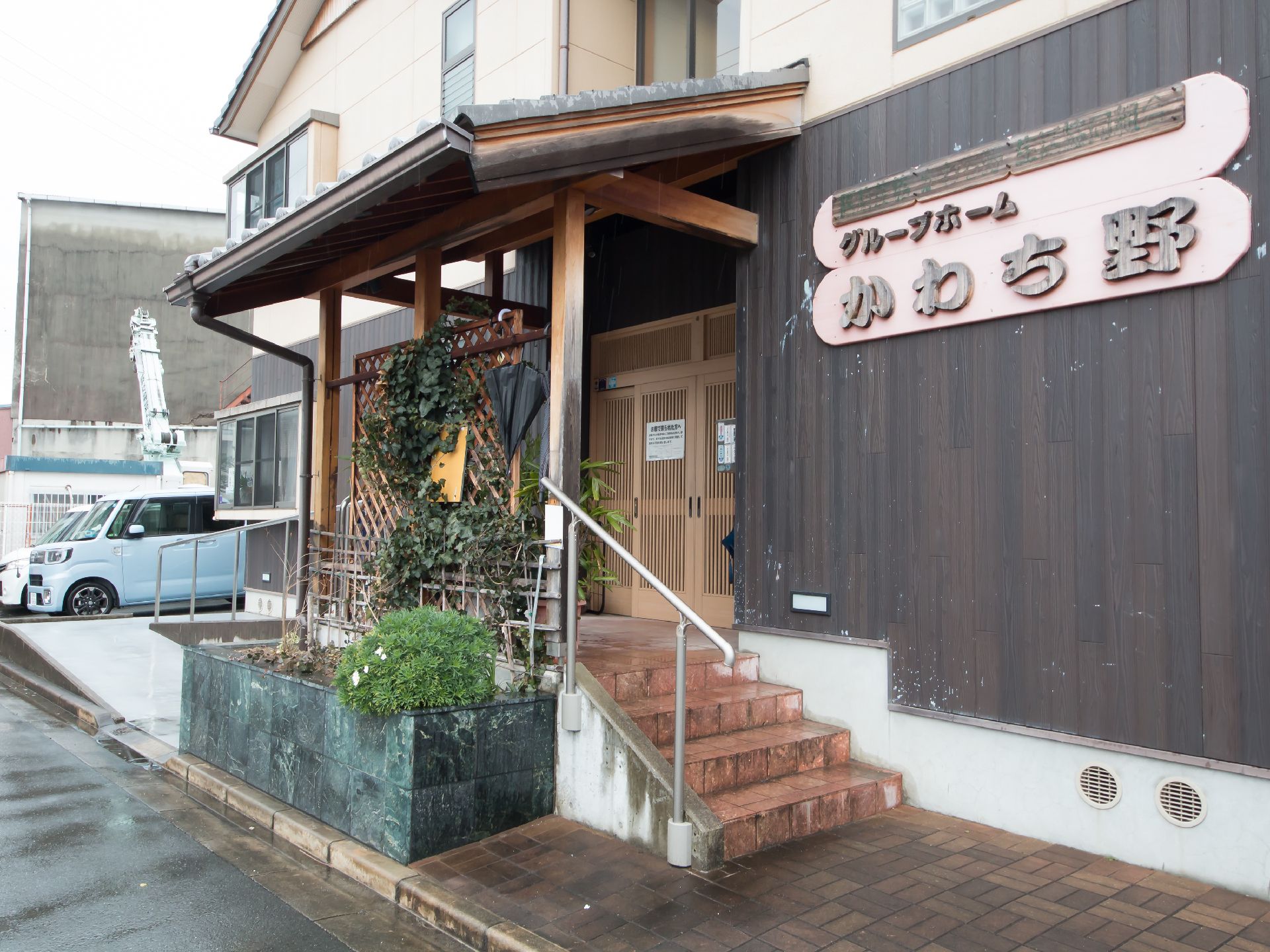 玄関先に手すり付きの階段とスロープが設置されている建物の入り口