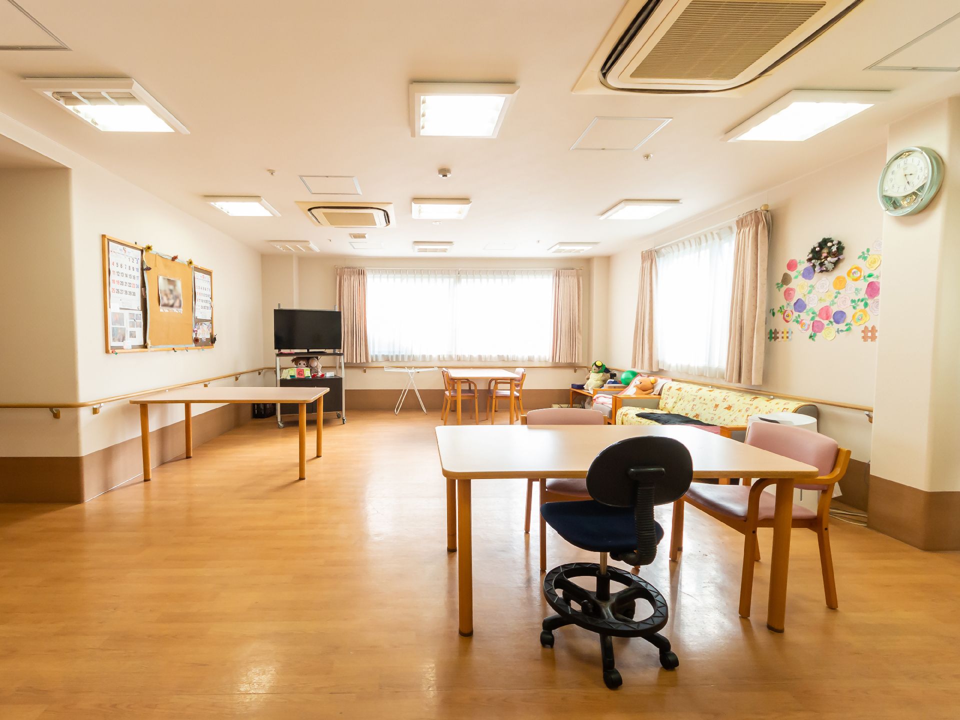 車いすに乗った女性を押す家族の男性とそこに寄り添う介護スタッフの様子