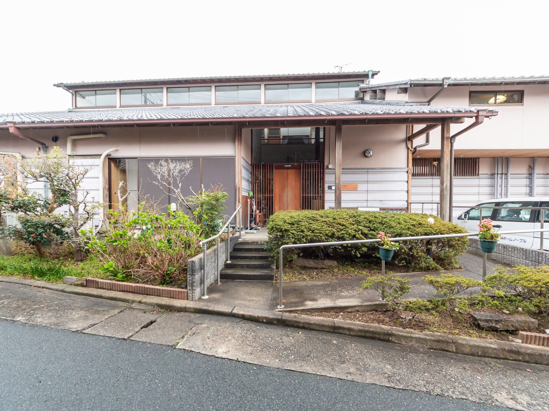 趣のある日本家屋。玄関周辺には木や花が植えられている。