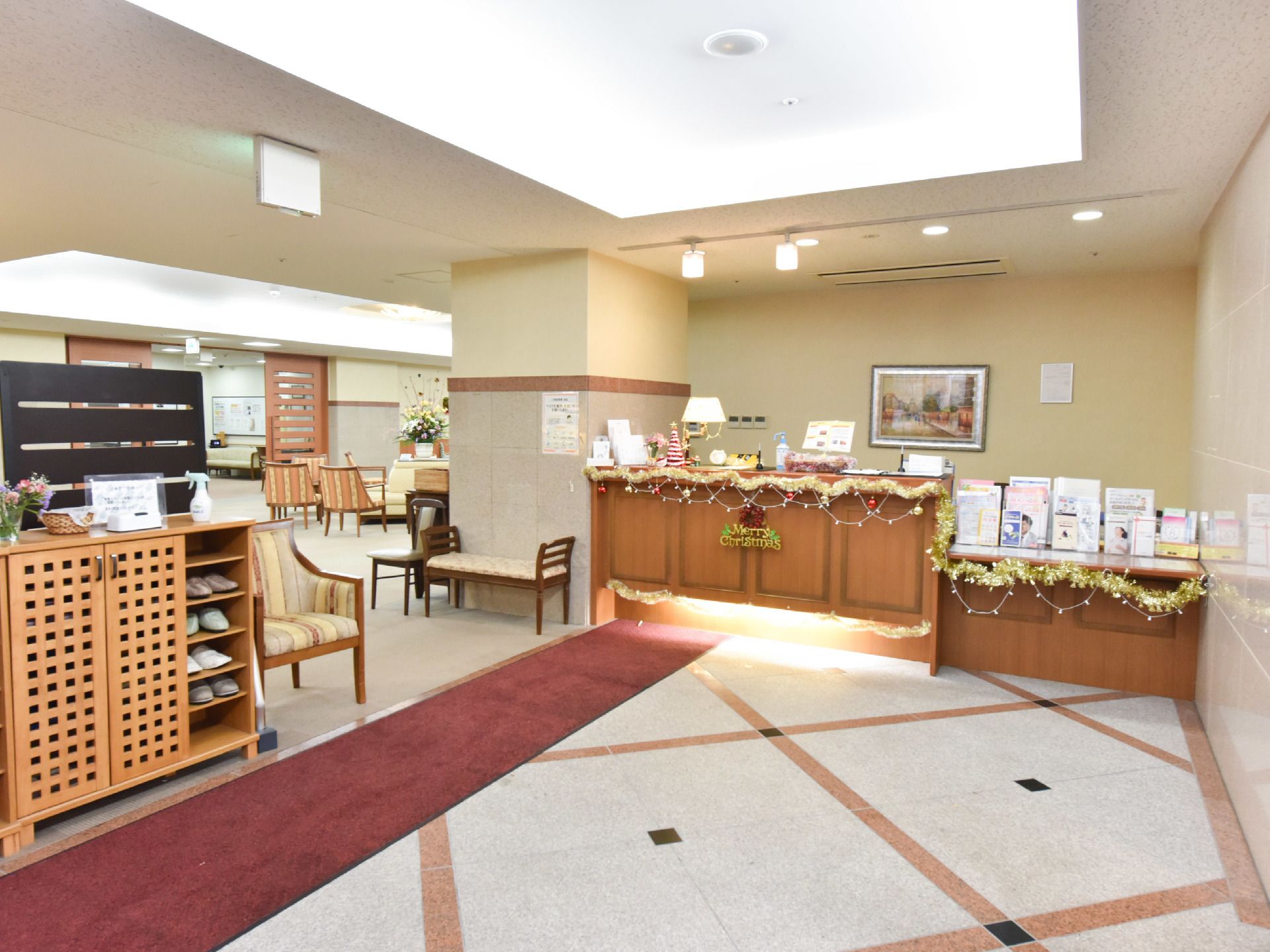 スリッパに履き替えてから、リビングに入ることができる。様々なパンフレットが並ぶ受付もあり、クリスマスの飾り付けがされてある。