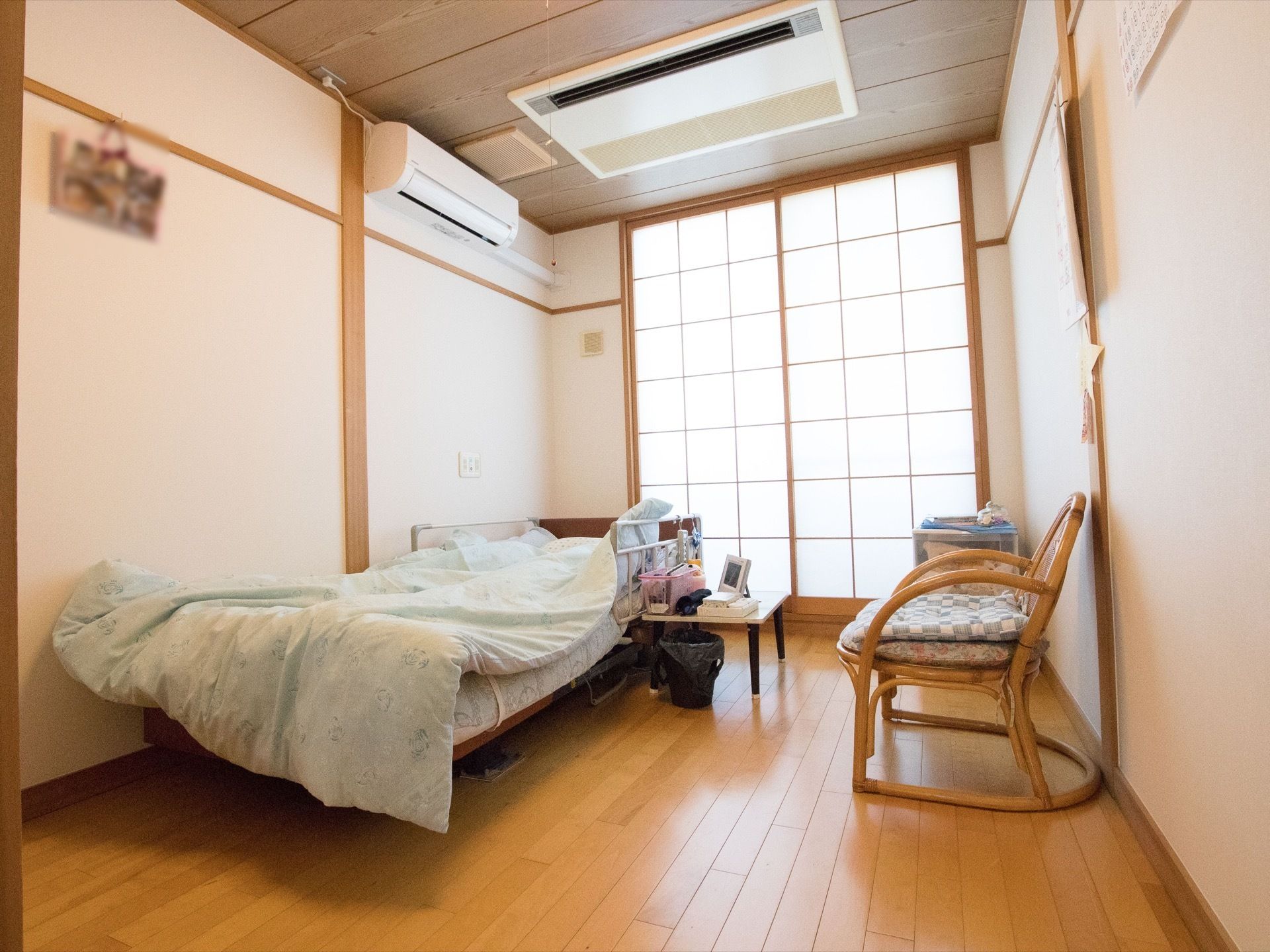 落ち着いた雰囲気の和風の居室である。フローリングの床に、籐製の椅子とリクライニングのベッドが置かれている。