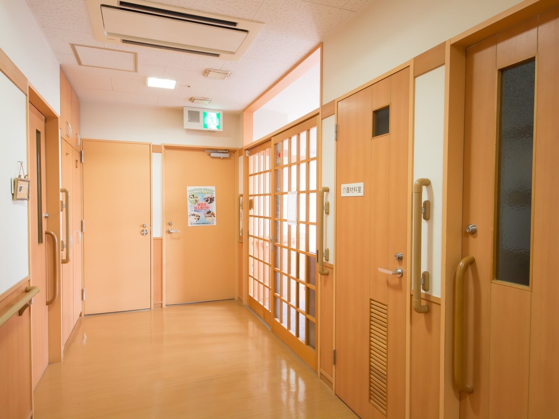芝生の上に座り微笑むスタッフと老夫婦。女性が男性の腕に手を置き、仲睦まじい様子。