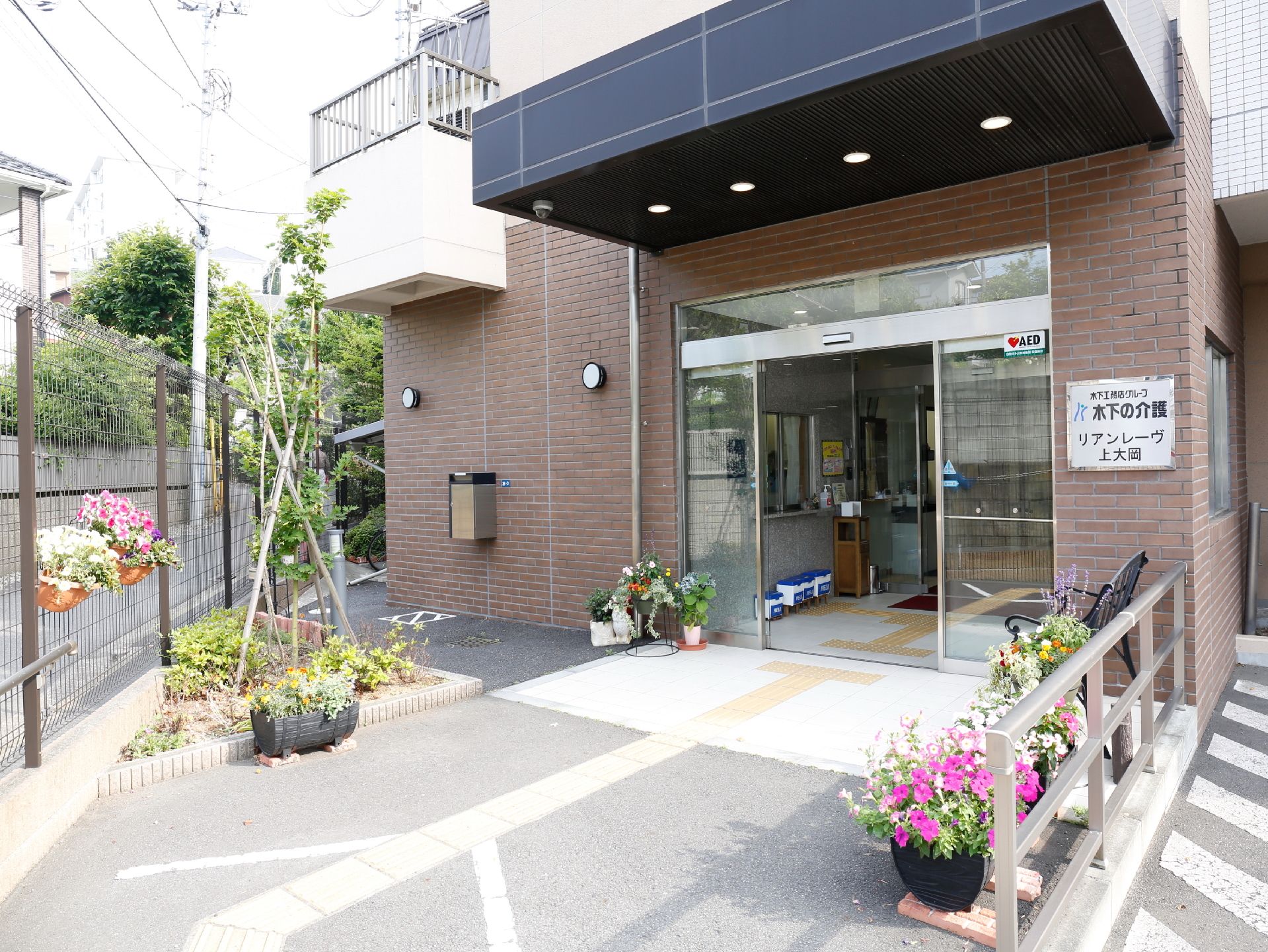 施設の入り口は自動ドアになっており車椅子でもそのまま入ることができる。点字ブロックもある。花が飾られている。