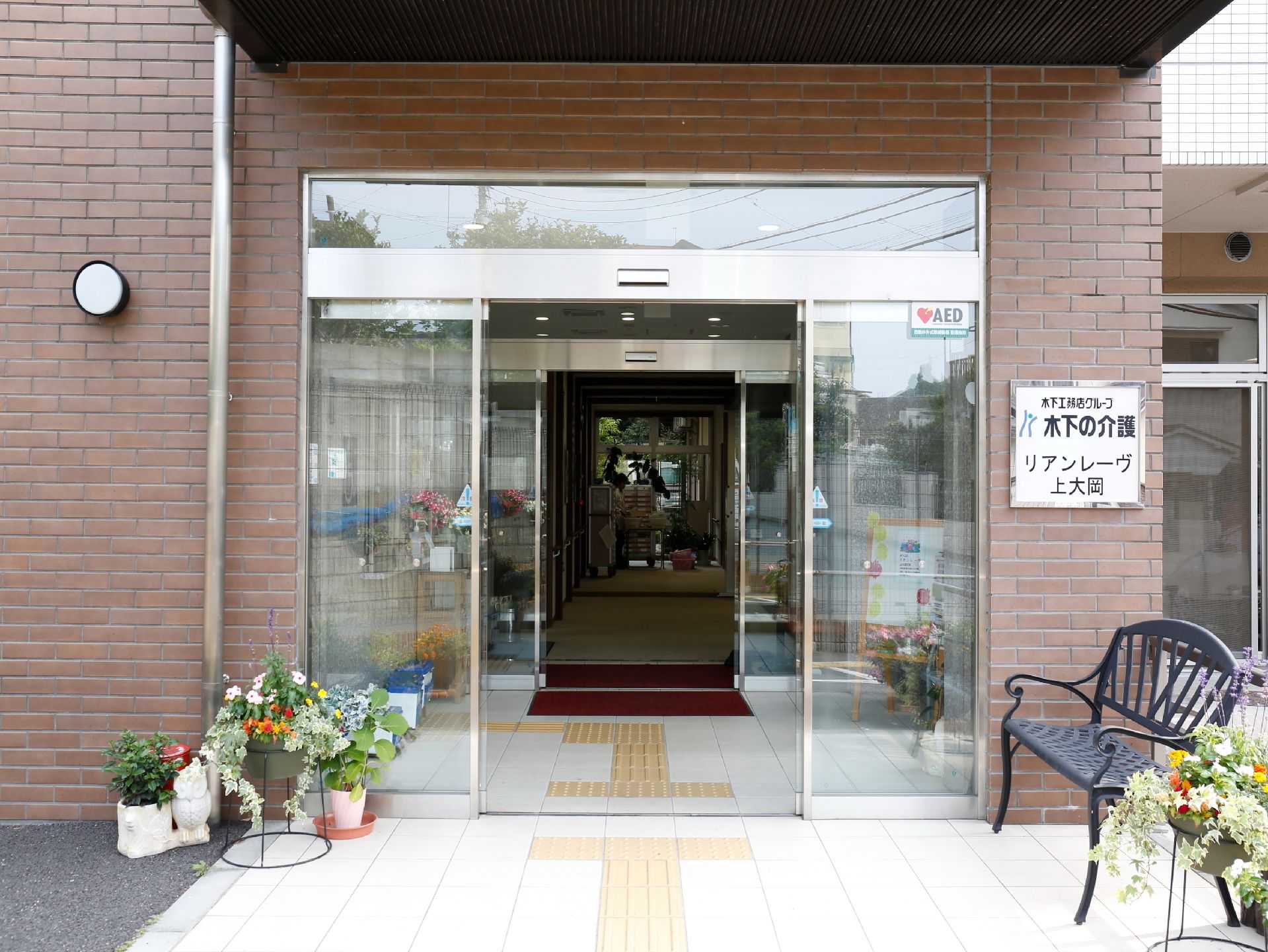 スタッフに付き添われながら、車椅子で散歩をする二名の入居者