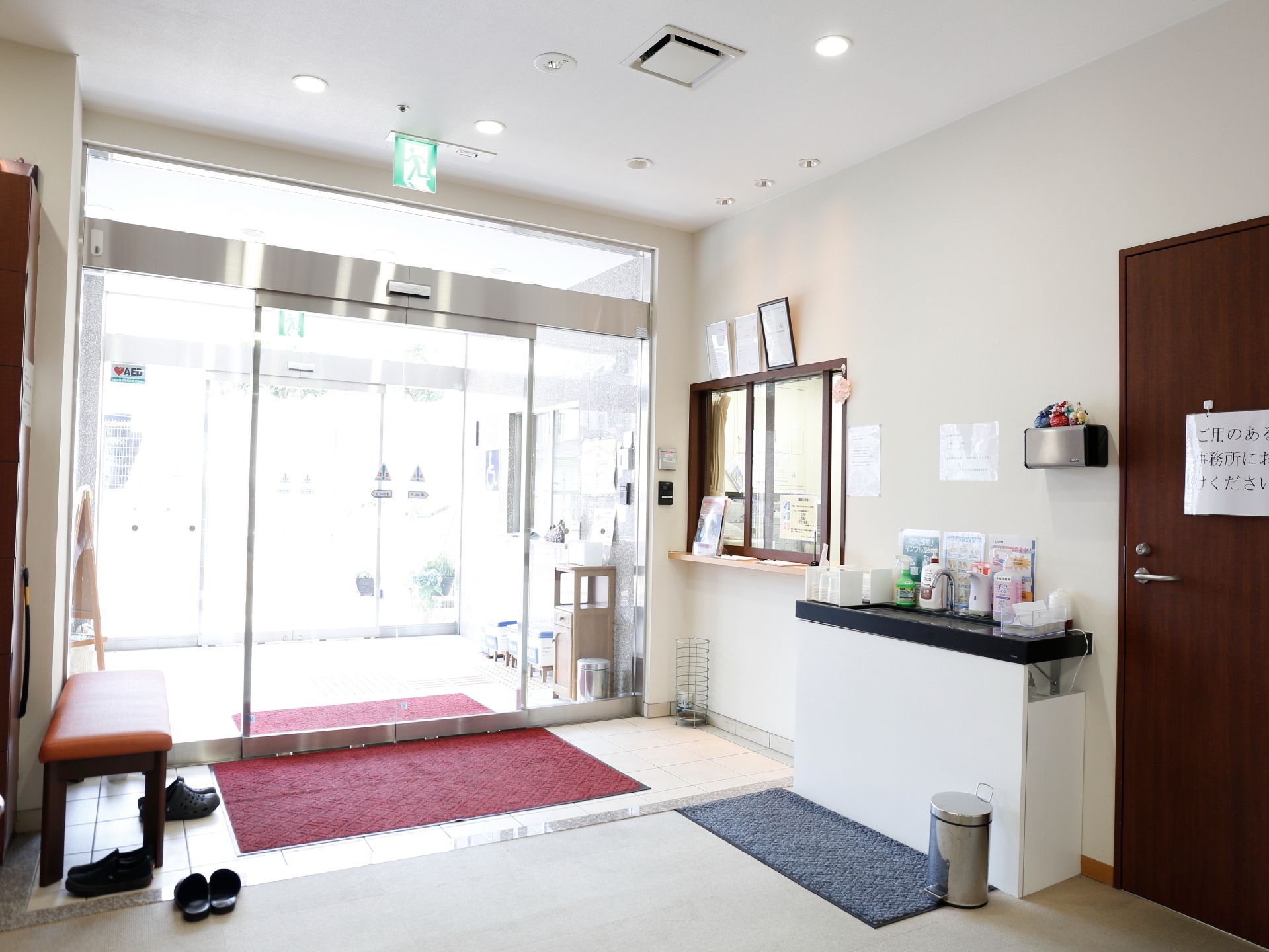 施設の玄関前にて、笑顔で写っている四人のスタッフたち