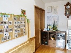 左側にイベント時の写真を掲示した壁がある。家庭用の収納スペースがあるリビングスペース