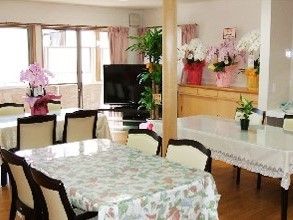 家庭用サイズのテーブルと椅子が複数並んでいる施設内のリビングスペース