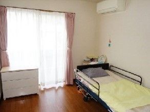 エアコンやタンス、ベッド、ベランダなどがある小さなワンルームタイプの部屋