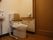 清潔感のある広々としたトイレである。トイレの周囲には、背もたれや手すりが完備され、立ち座りの動作の負担を軽減している。