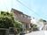 施設は2階建てで、一般的な家を大きくしたような造りになっている。施設の前には多くのプランターが置かれている。