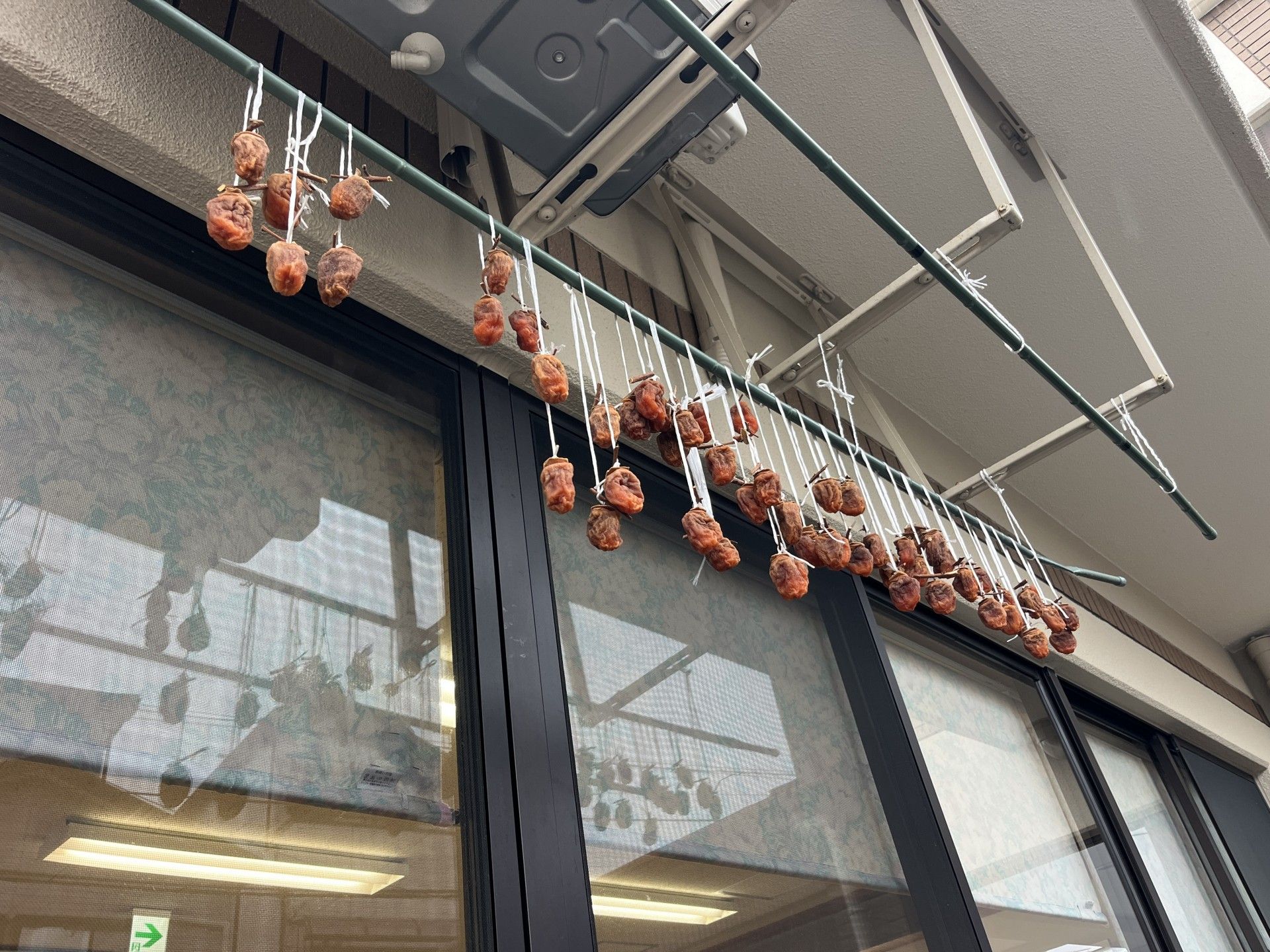 干し柿が吊るされた窓辺