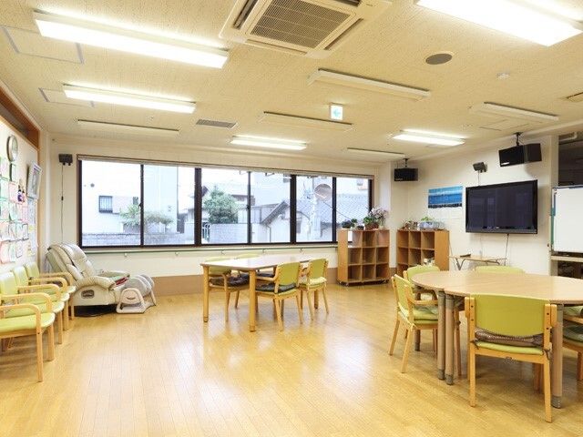 ライトグリーンの椅子がセットされた六角系のダイニングテーブルセットが複数置かれた食堂にはテレビもある。