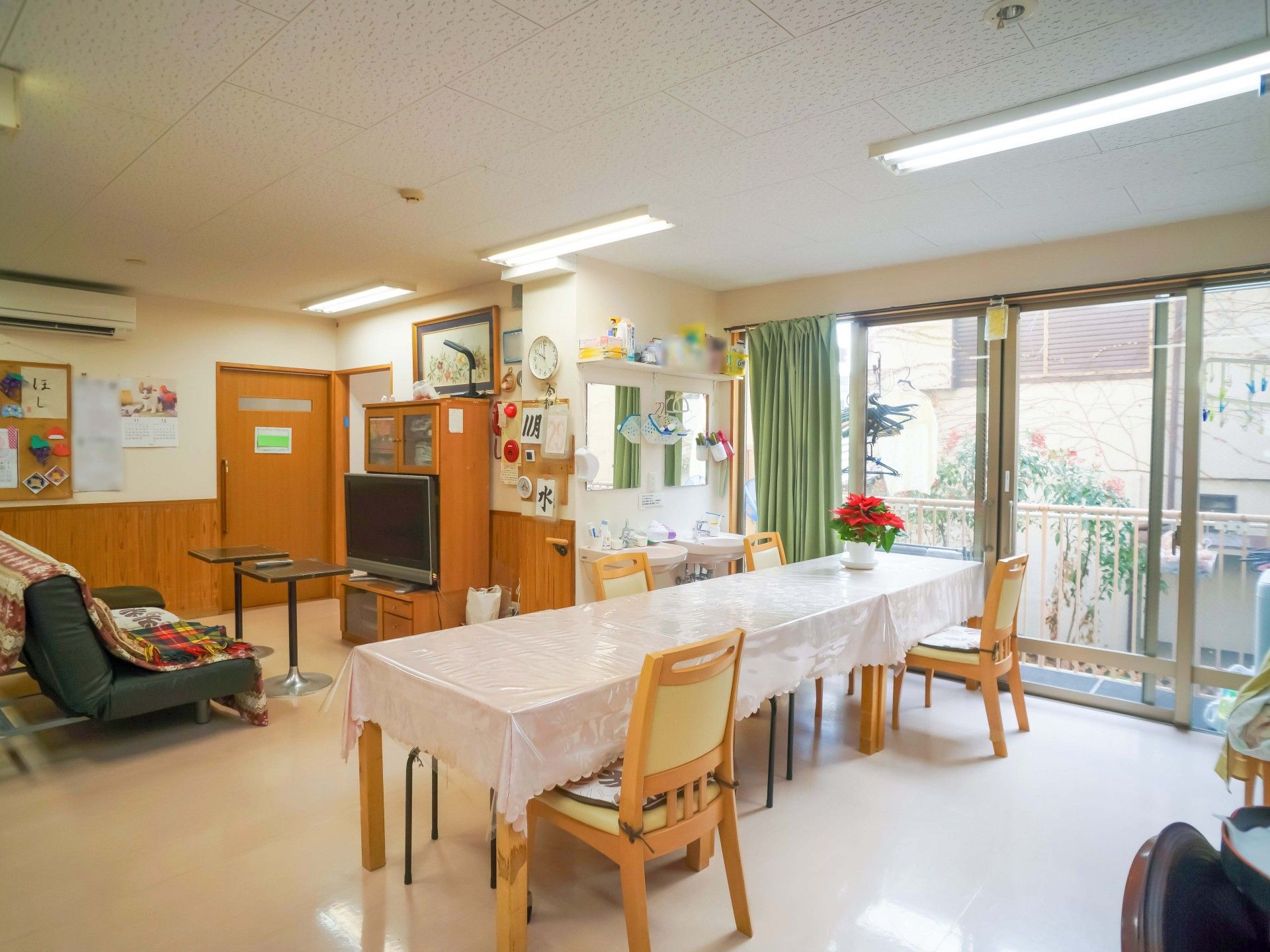 受付にて椅子に座ってパソコンを使いながら業務を行ってる女性スタッフ。