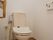 白を基調とした、掃除が行き届き清潔なトイレである。手すりを設けることで、立ち座りの動作における負担を軽減している。