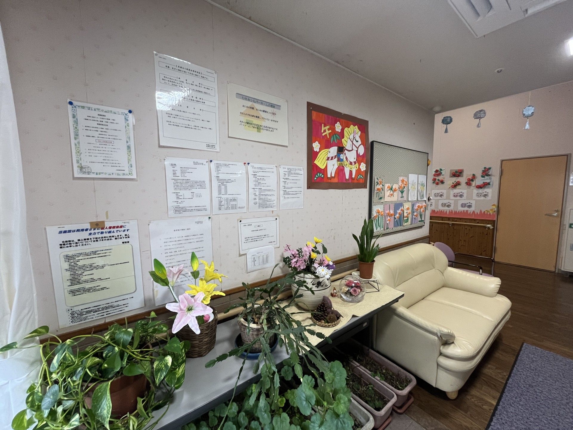壁に掲示物と植物がある部屋