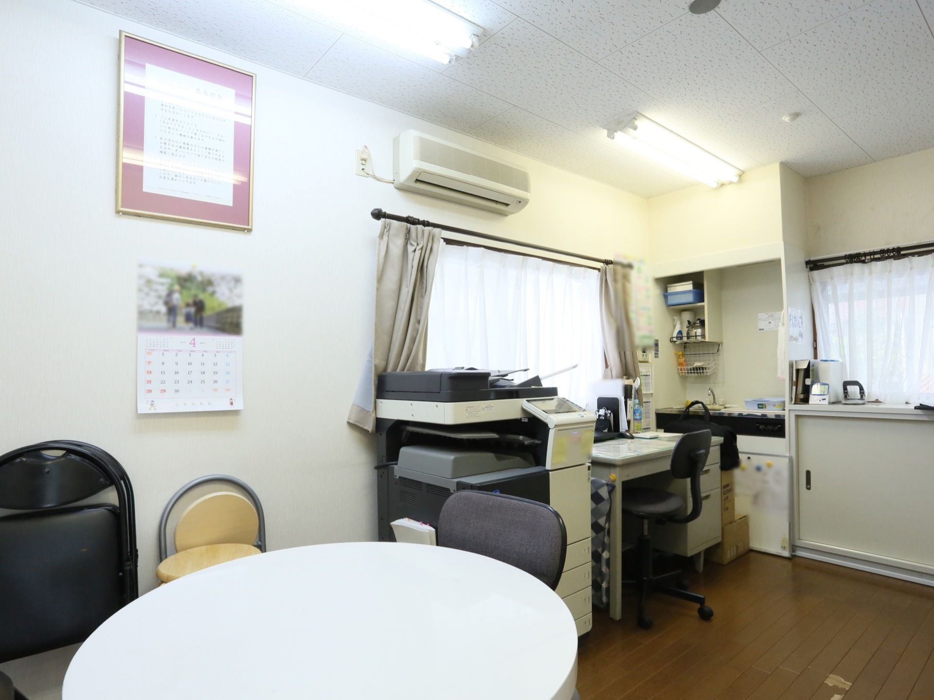 室内が白い内装で統一された事務室は、明るく清潔感がある。家具や事務機器を壁際に寄せて配置してあるので広々としている。