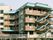ブラウンとグリーンの大きな建物。屋外には避難用階段も付いている。