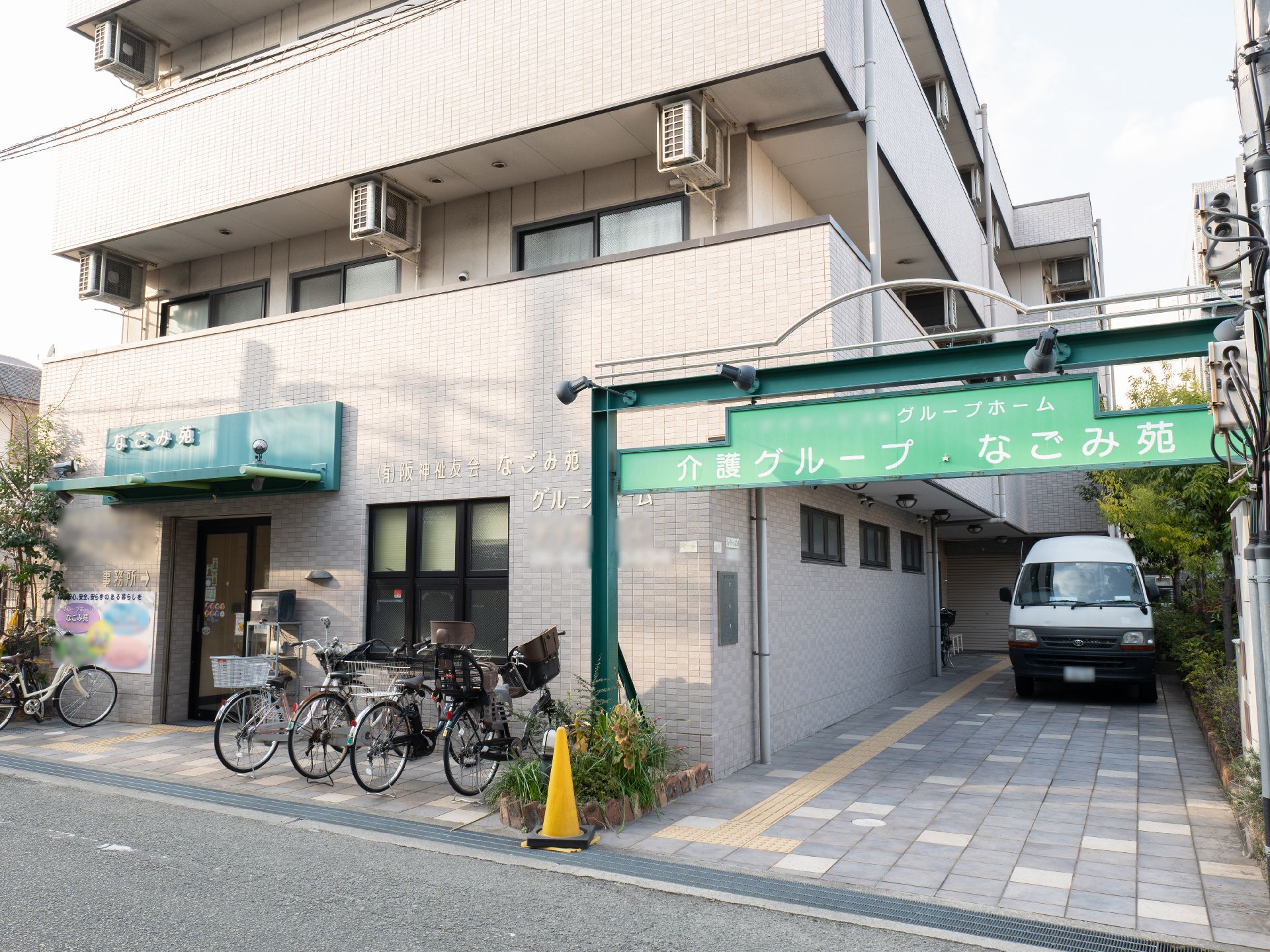 各フロアにベランダがあり、ホーム名が書かれたアーチや屋根が付いているグレー系の外観の3階建ての建物