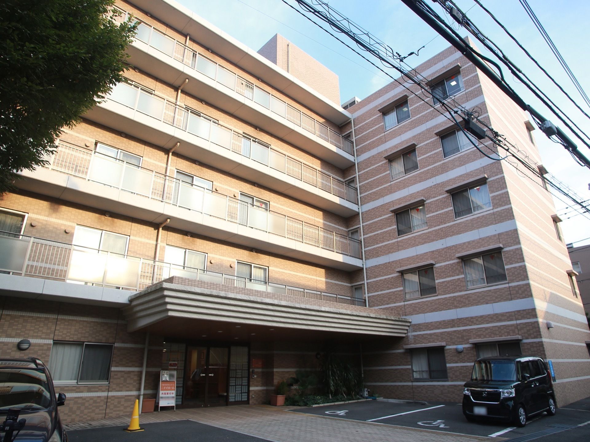 鉄筋コンクリート造りの５階建ての施設。建物の正面に、優先駐車場が２箇所あり、段差のないタイル張りの舗道がある。