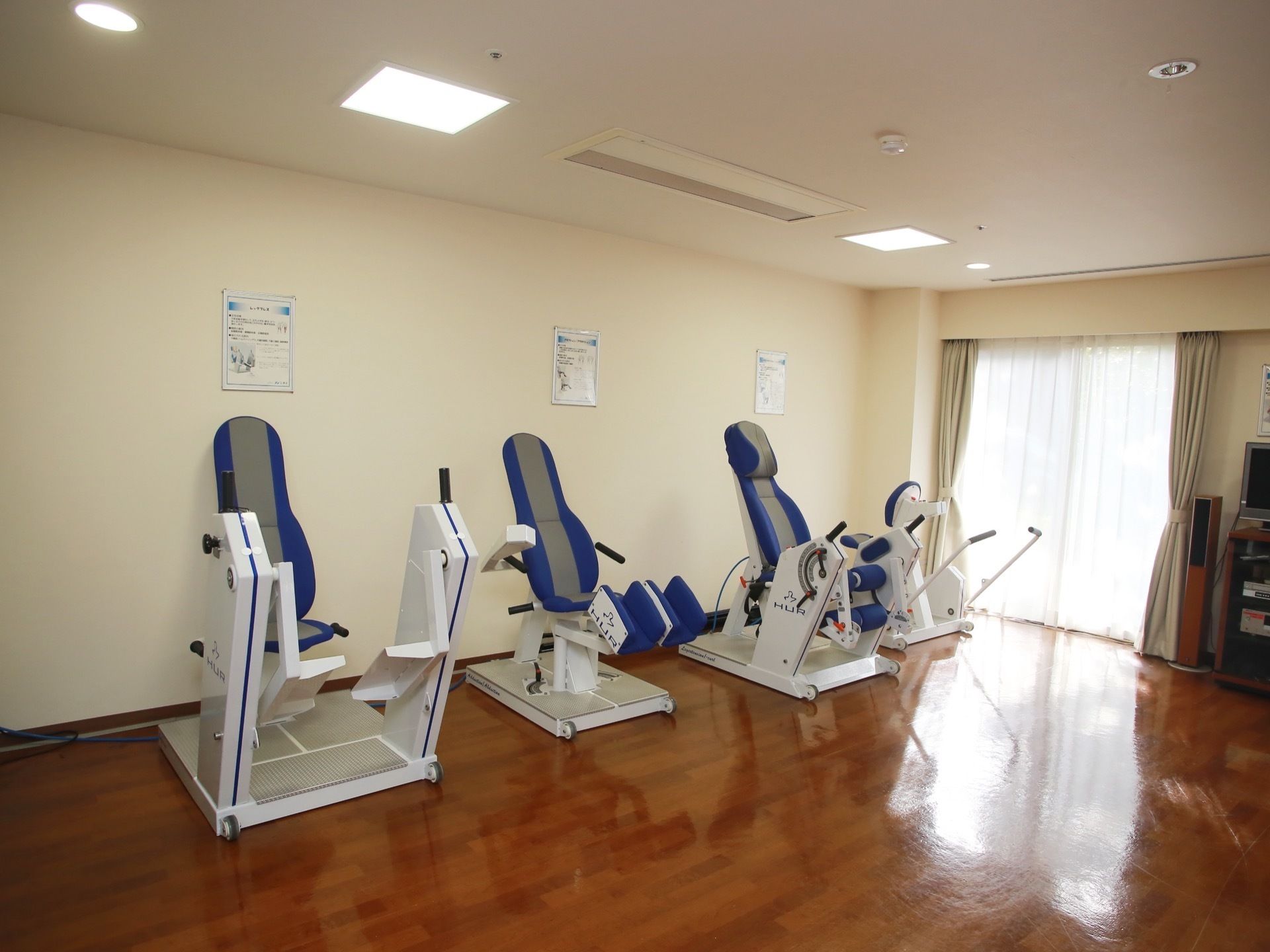 窓のある部屋に、４種類のトレーニングマシンが設置されている。すべて座ったままの姿勢で使用するタイプで、負荷の調整ができる機械である。