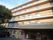 地上５階建ての鉄筋コンクリート造りの施設。左側がアスファルトになっており、自動車が１台駐まっている。