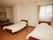 窓のある広い部屋に、ベッドが２台並んでおり、奧にはダイニングセットとキッチンが見える。左側のベッドのそばにナースコールが設置されている。