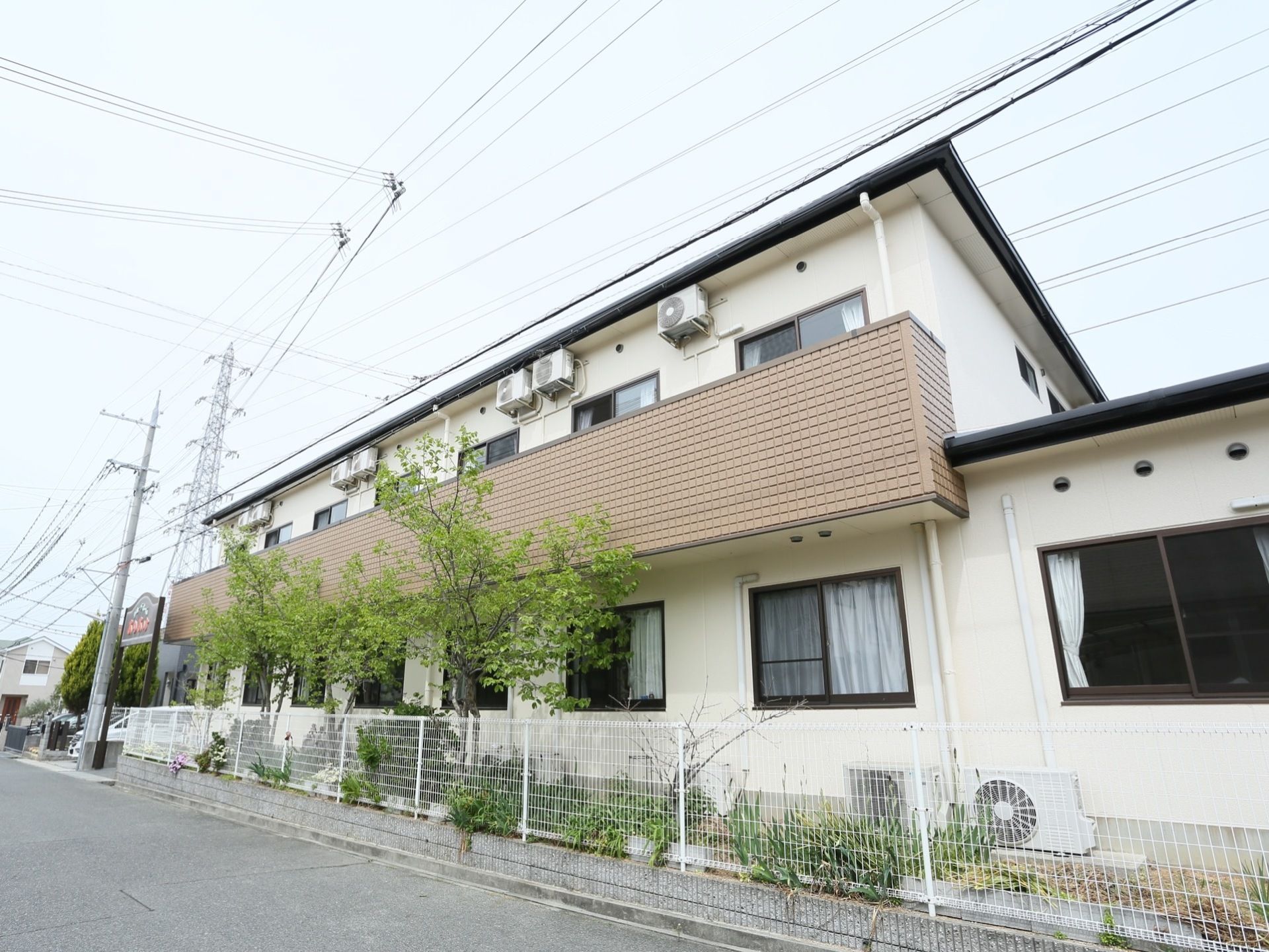 白を基調とした２階建ての建物になっている。２階部分にはバルコニーが設置されている。周囲にさまざまな植栽が施されている。