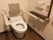 便器の両サイドに肘掛けサイズの手すりがあり、立ち座りの動作も安心である。トイレの蓋の代わりに背もたれがあり、快適に使用できる。
