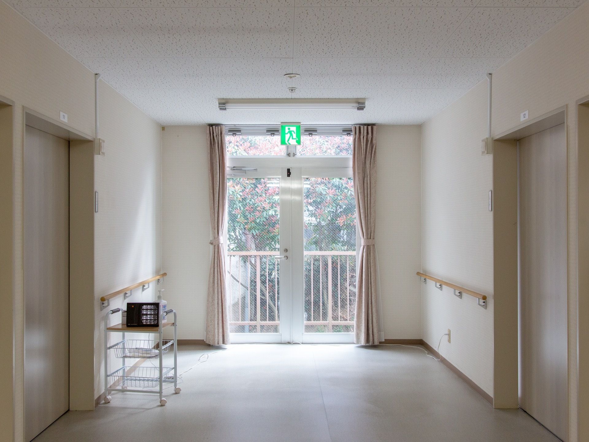 通路の突き当りには非常口を設置している。夜でも位置が分かるように非常灯で案内している。使わない時は鍵が掛けられるようになっている。