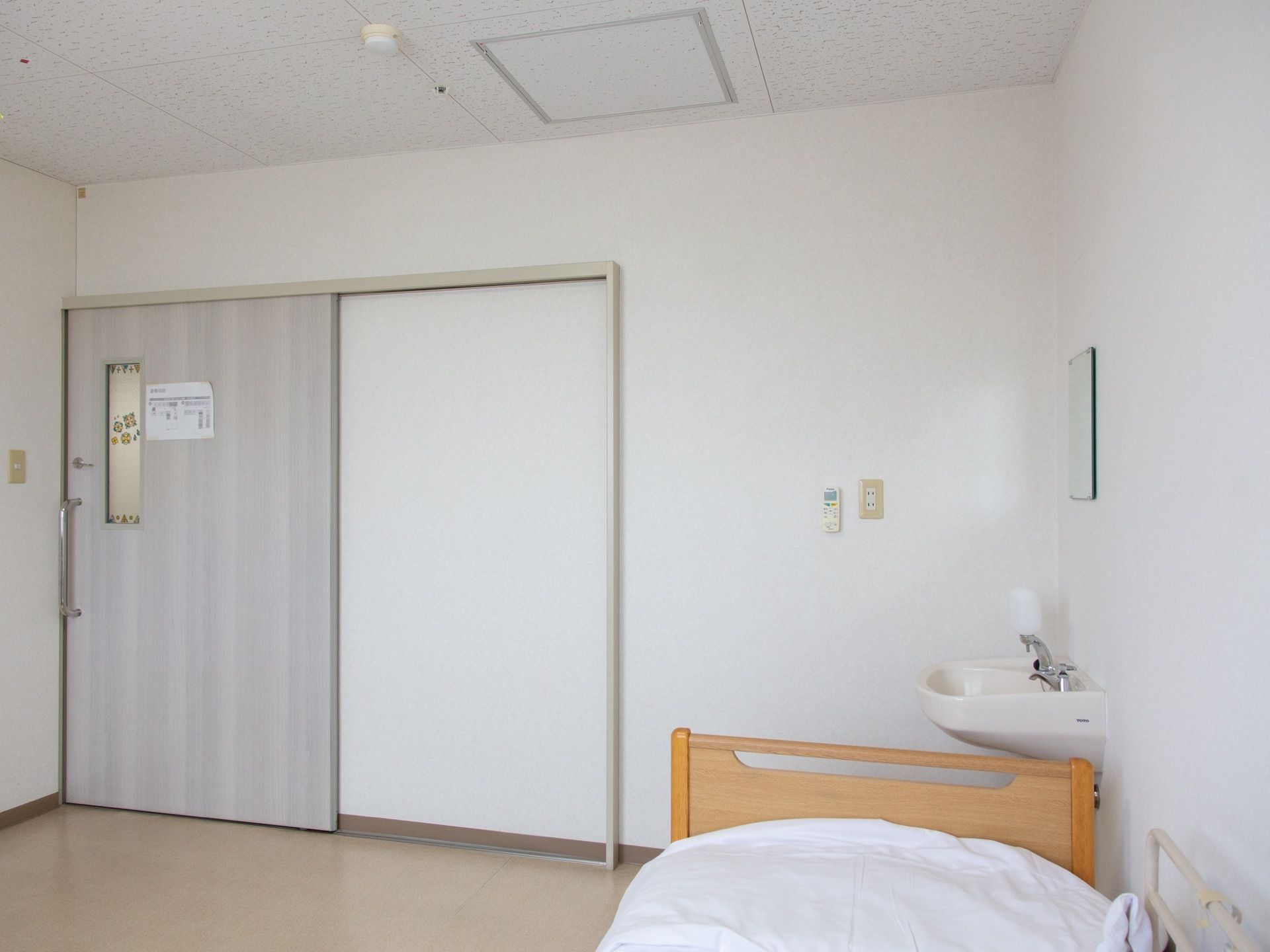 居室の扉は薄いグレーの引き戸になっている。花柄のすりガラスの小窓が付いていて、かわいいイメージになっている。