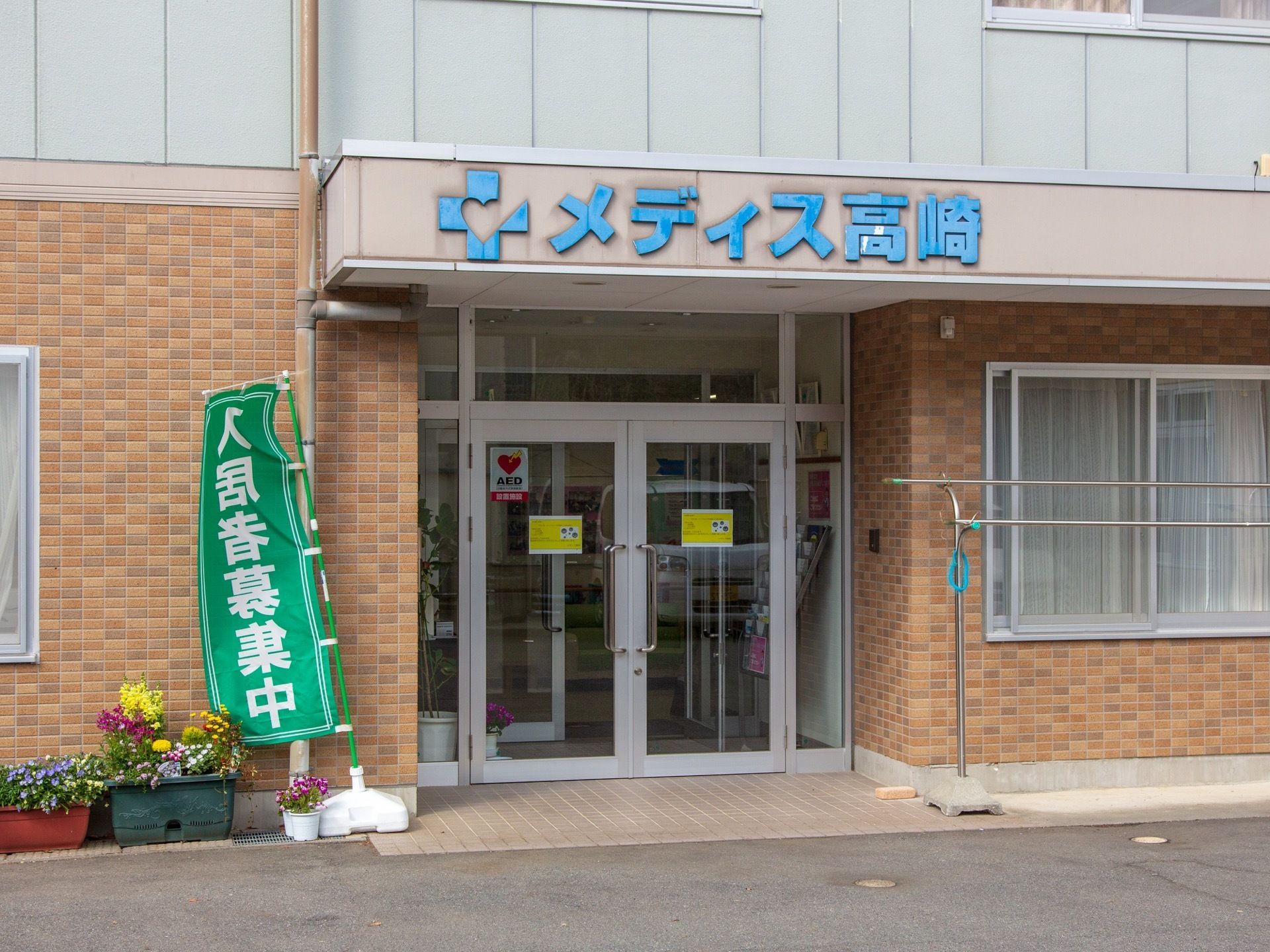 施設の1階の外壁は煉瓦調になっている。玄関はガラス扉で両開きになっている。玄関の屋根部分に施設名が大きく表示されている。