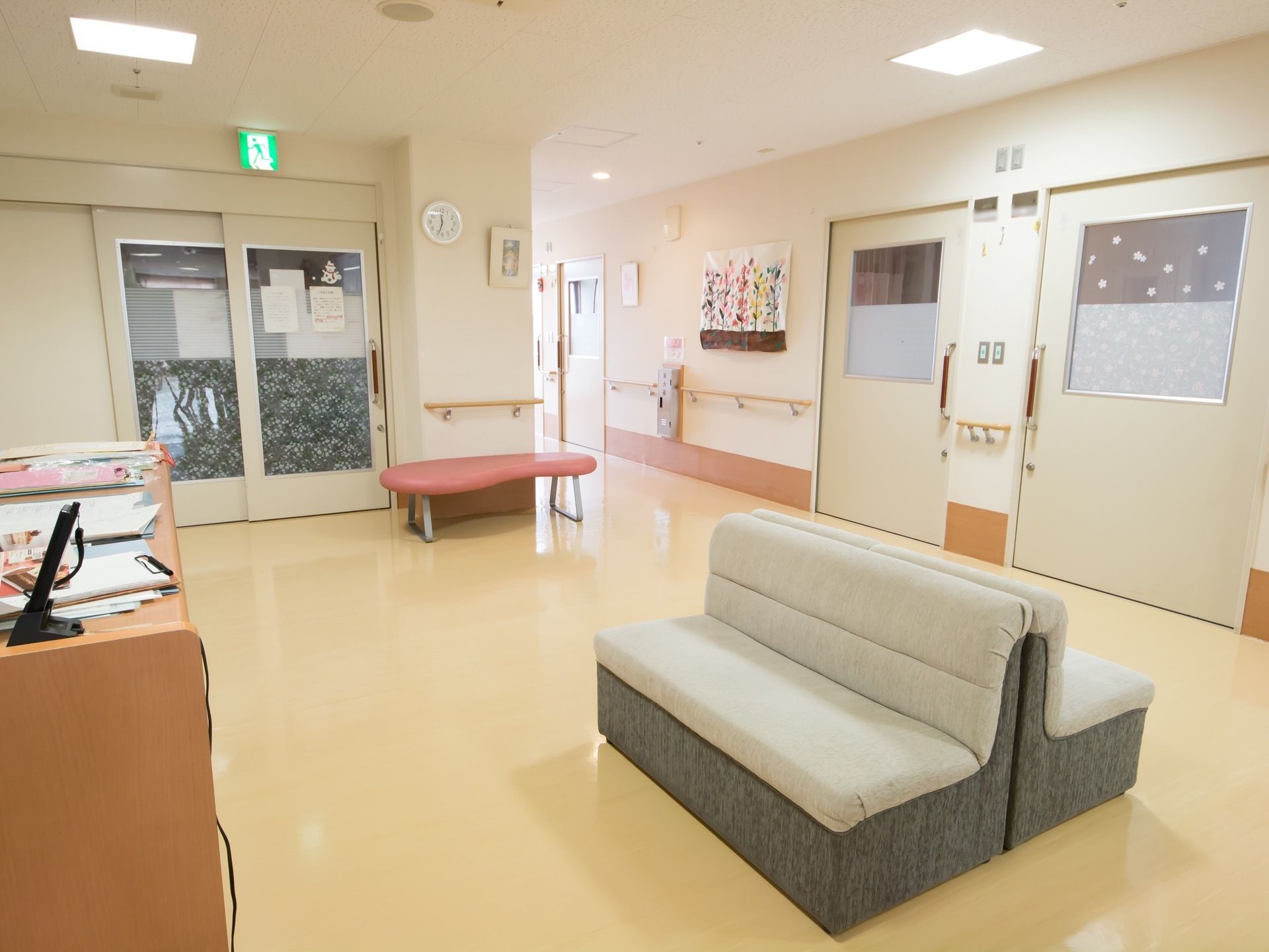 廊下は明るく広々として開放的。各所に自由に利用できる長椅子やソファーが設置されている。手作りの壁面装飾が家庭的なあたたかみを感じさせる。