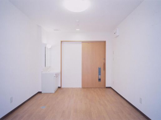 フローリングの居室には大き目の洗面所が付き、家具などはなく、出入り口には引き戸が設置されている。