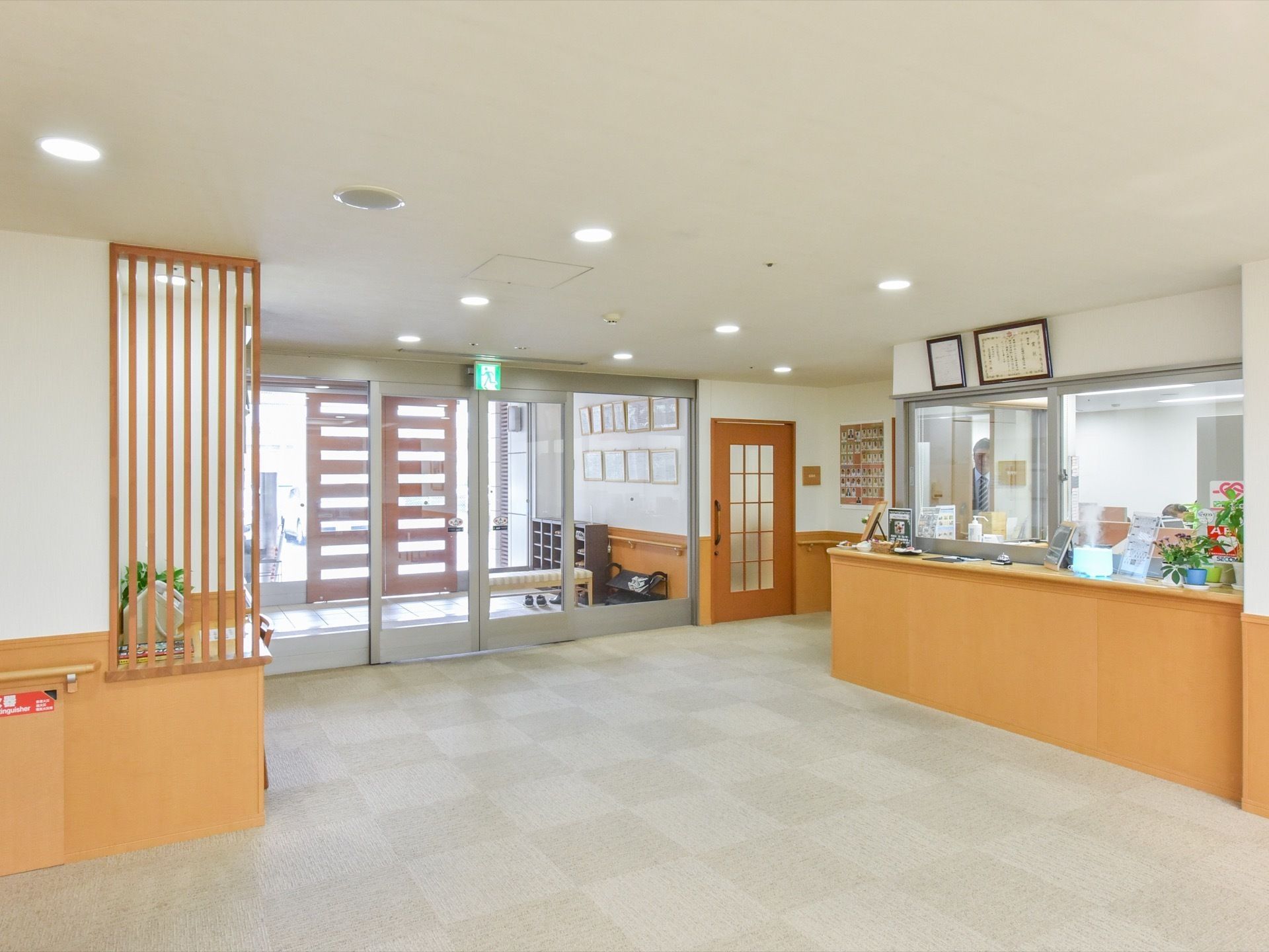 広々とした玄関ホールの右側に、受付窓口が設置されている。ベージュ色のカウンターの上には、様々な物が置いてある。