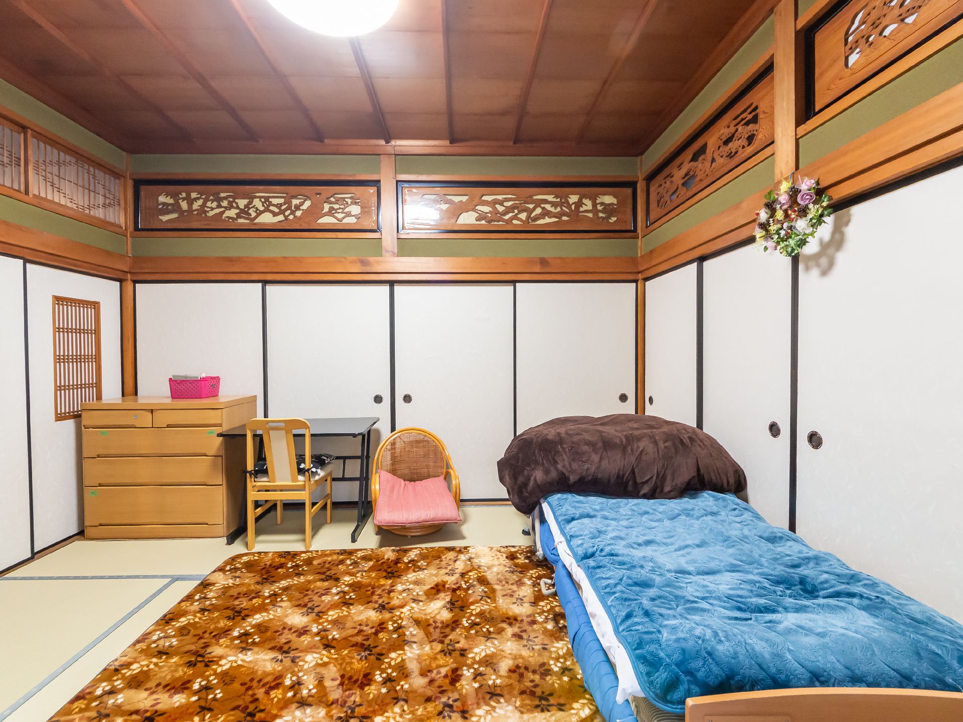 輪になってレクリエーションをする高齢女性と女性スタッフ