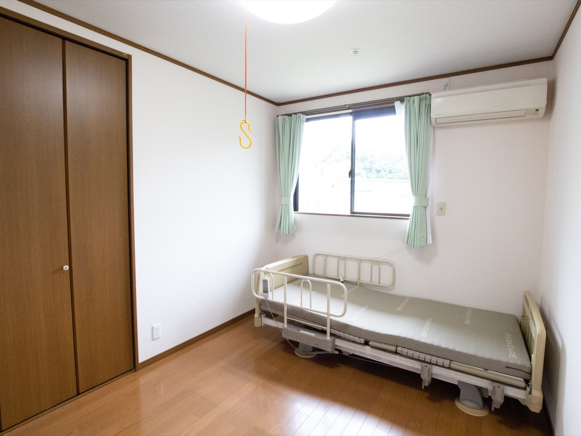 窓があり、その横にはエアコンが設置されている。壁に沿ってベッドが用意されている。クローゼットが完備されている。